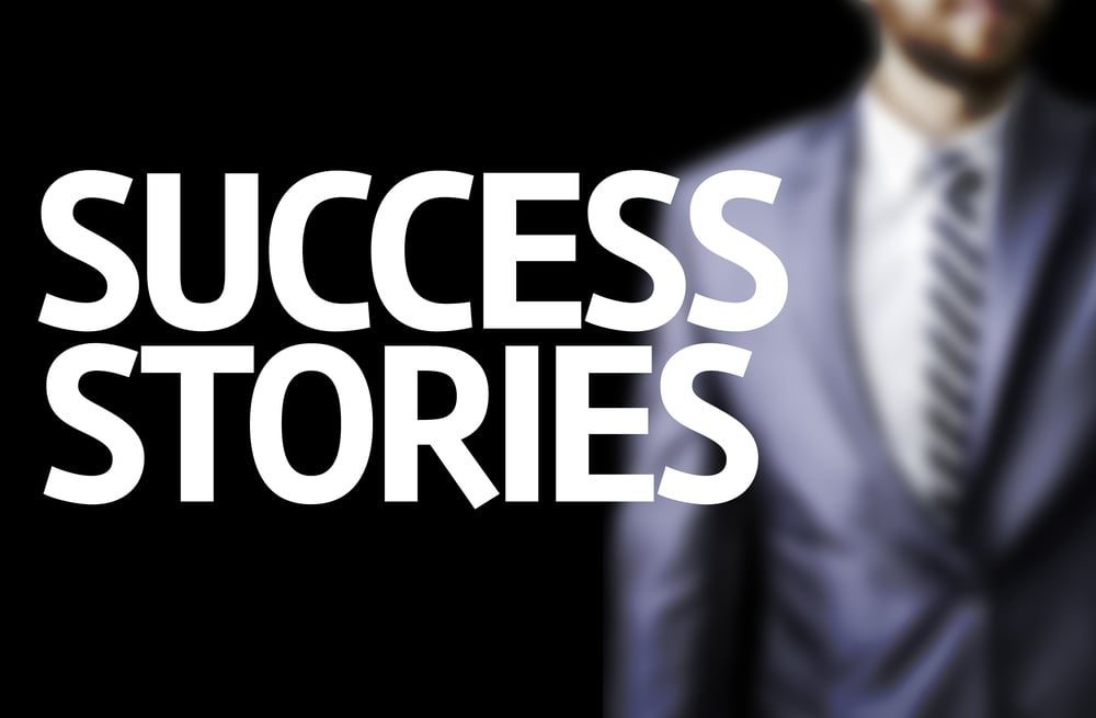 Success Stories written on a board with a business man on background